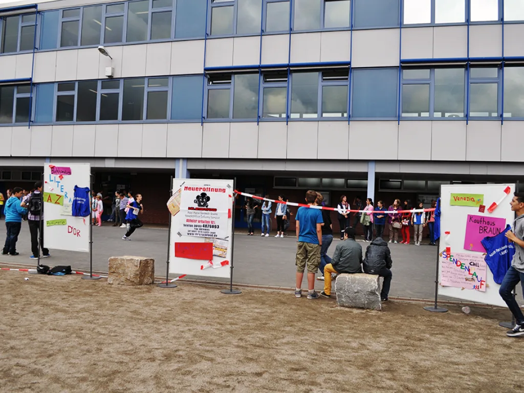 Läufer passieren einen Stand mit Plakaten.